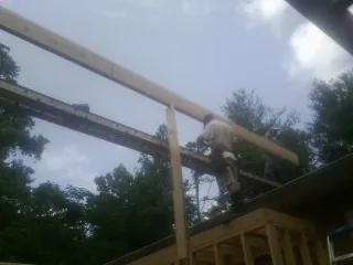 Carpenter setting a ridge beam over a new addition frame — Ice Dam Removal by Roofing Brothers in Edmond
