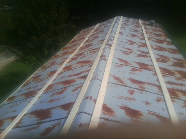 Rusted metal roof panels with new wood purlins before replacement — Storm Damage Roof Repair in Edmond by Roofing Brothers