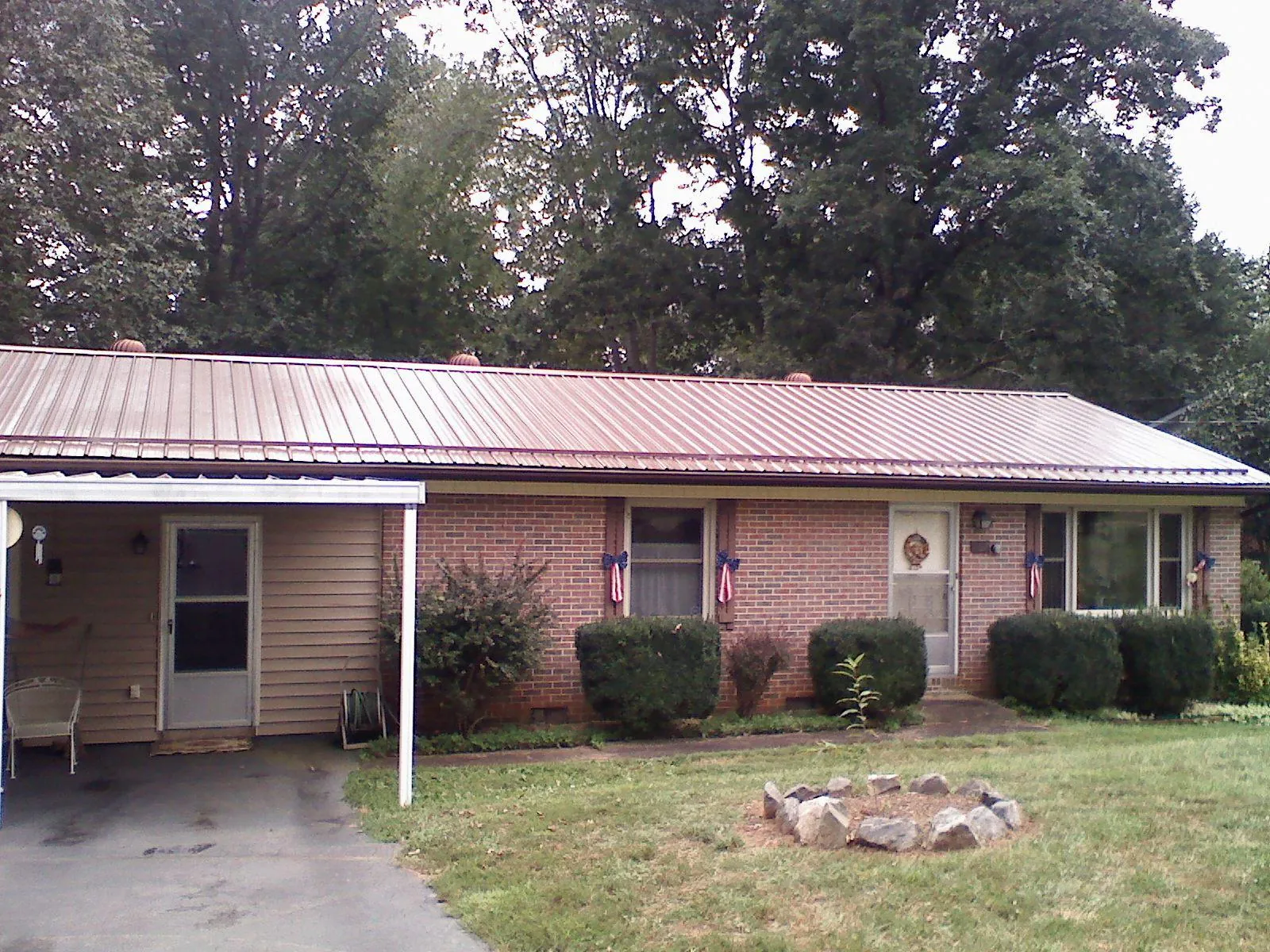Bronze metal roof and carport on a brick ranch home — Roof Repair work by our crew in Edmond